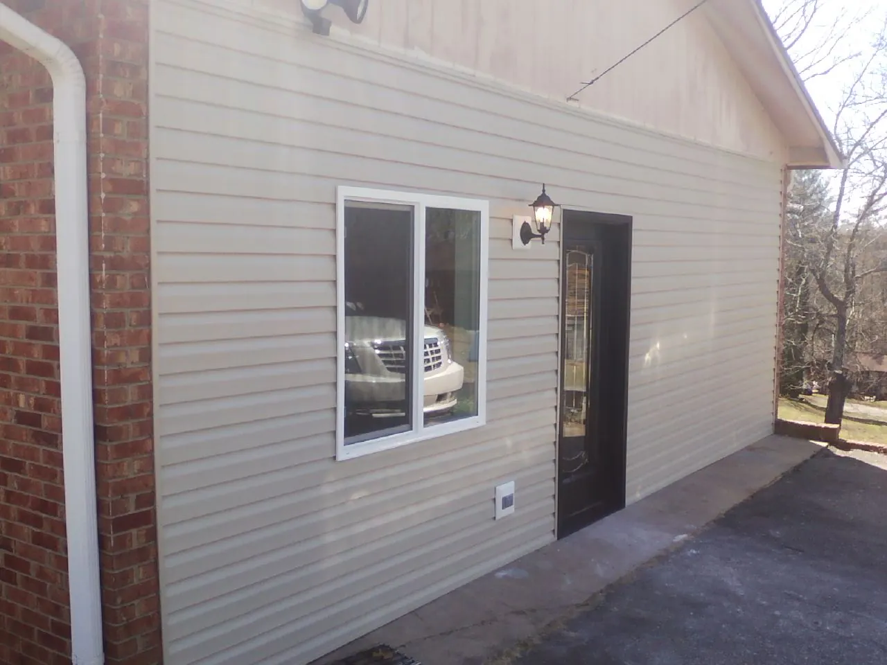 New vinyl siding and entry door on a room addition in Old Fort