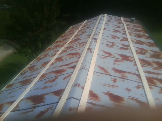 Rusted metal roof panels with new wood purlins before replacement — Storm Damage Roof Repair in Old Fort by Roofing Brothers