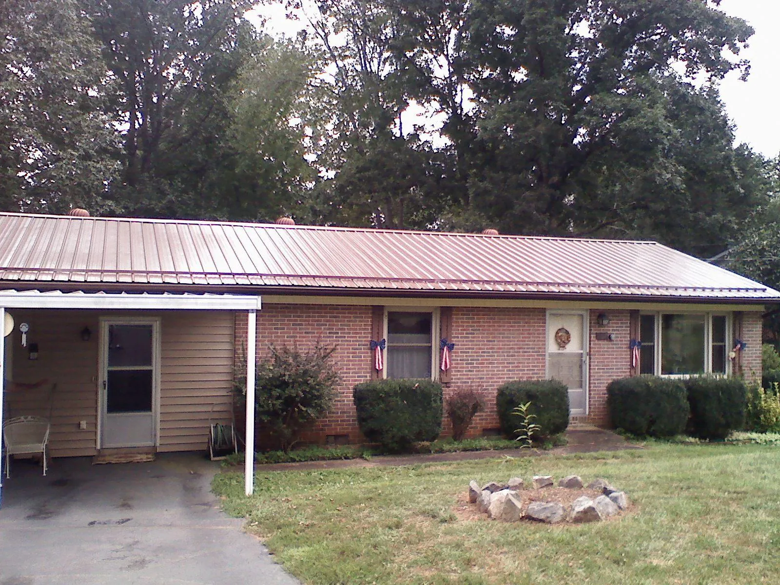 Bronze metal roof and carport on a brick ranch home — Roof Repair work by our crew in Old Fort